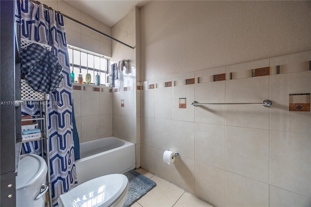 bathroom with tile patterned floors, shower / bath combo with shower curtain, and toilet