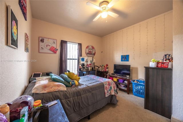 carpeted bedroom featuring ceiling fan and a textured ceiling