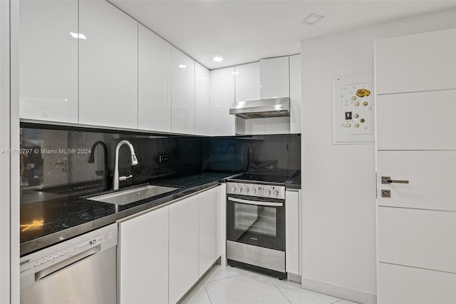 kitchen featuring sink, range hood, backsplash, white cabinets, and appliances with stainless steel finishes