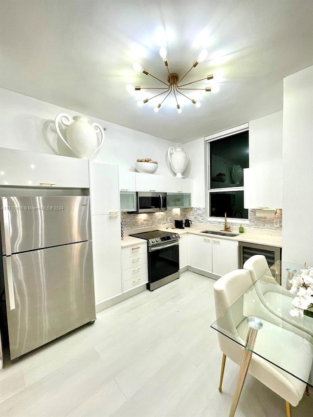 kitchen featuring white cabinets, backsplash, sink, and appliances with stainless steel finishes