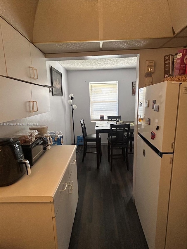 kitchen featuring white fridge and dark hardwood / wood-style floors