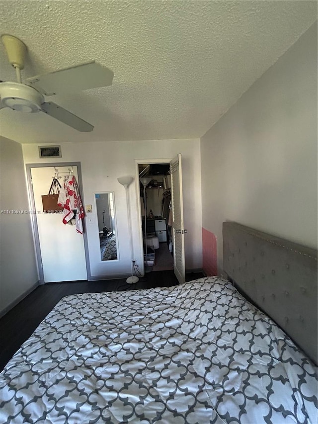 unfurnished bedroom featuring hardwood / wood-style floors, ceiling fan, and a textured ceiling