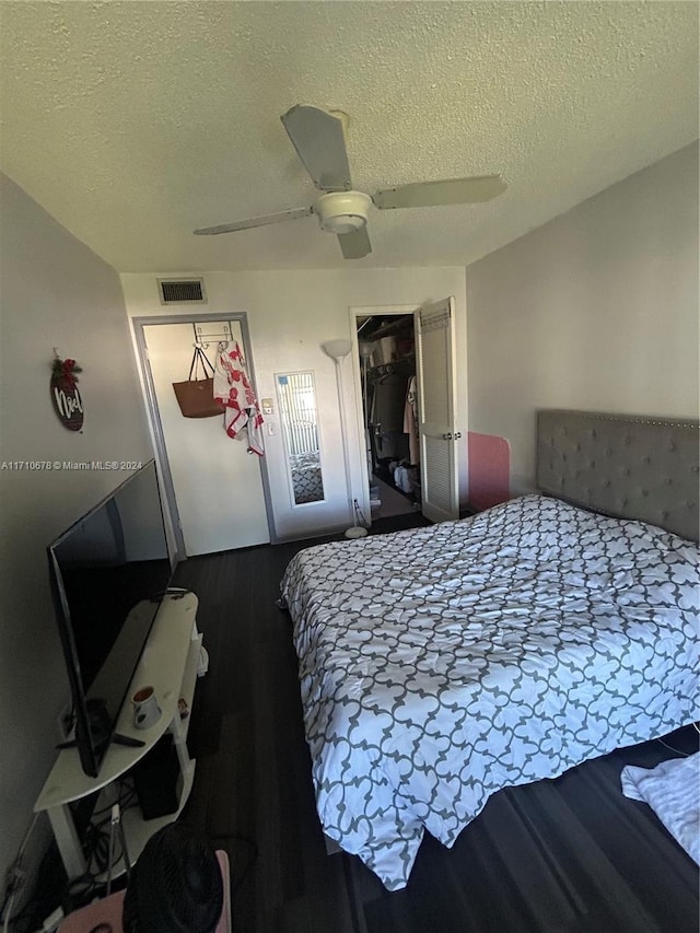 bedroom with hardwood / wood-style flooring, ceiling fan, a textured ceiling, and a closet