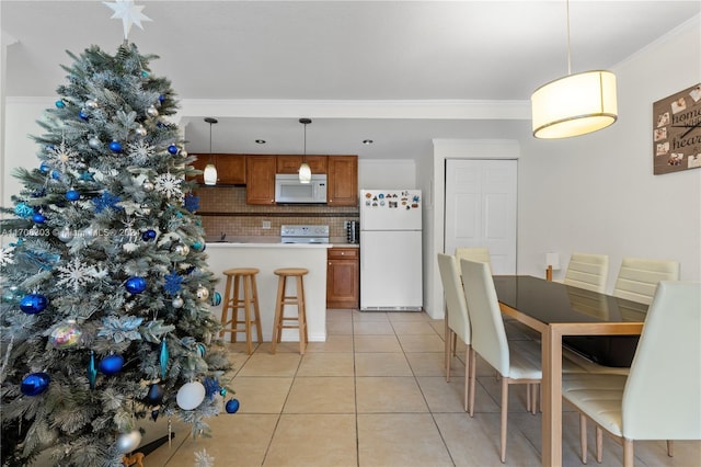 kitchen featuring decorative backsplash, pendant lighting, white appliances, and ornamental molding