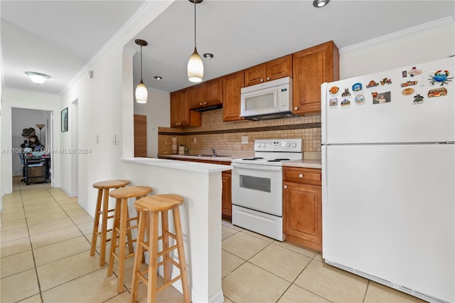 kitchen with pendant lighting, white appliances, light tile patterned floors, and crown molding