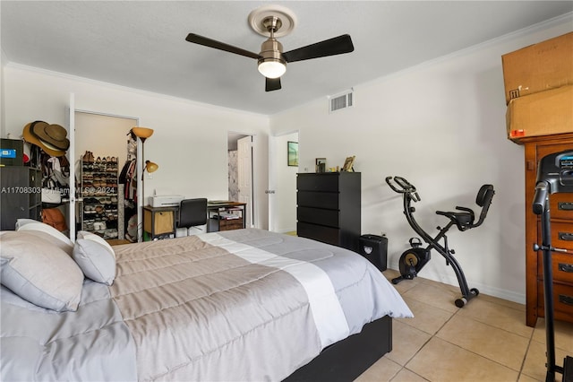 bedroom featuring crown molding, ceiling fan, a spacious closet, light tile patterned floors, and a closet