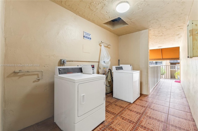 laundry area featuring washing machine and clothes dryer and a textured ceiling