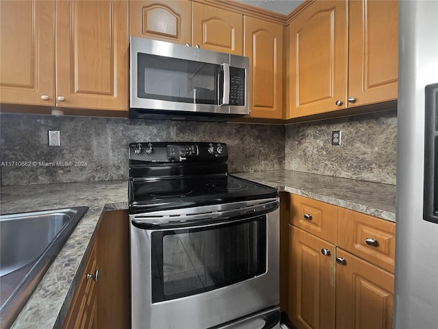 kitchen featuring decorative backsplash, sink, and stainless steel appliances