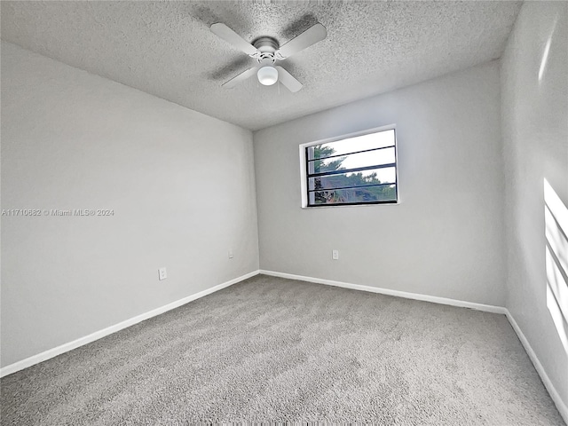 carpeted empty room featuring ceiling fan and a textured ceiling