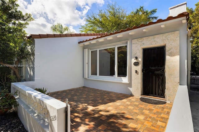 view of exterior entry featuring a patio area