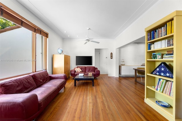 living room with ceiling fan, wood-type flooring, and ornamental molding