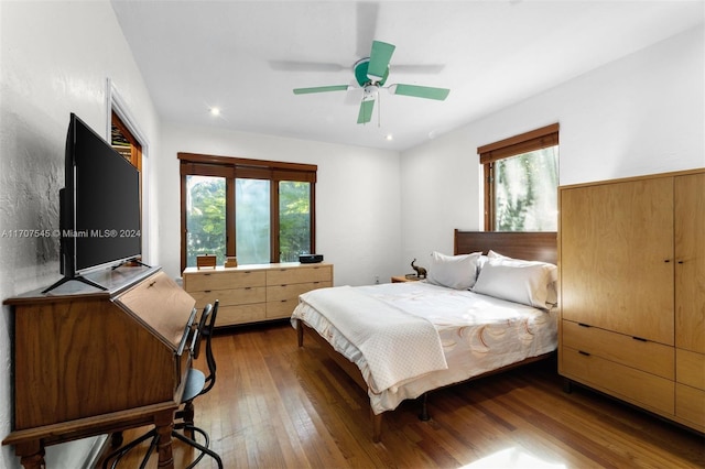 bedroom with multiple windows, dark wood-type flooring, and ceiling fan