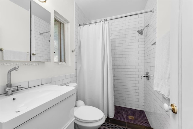 bathroom with vanity, toilet, walk in shower, and tile walls