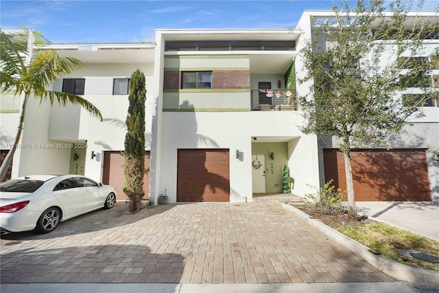 view of front of property featuring a garage and a balcony