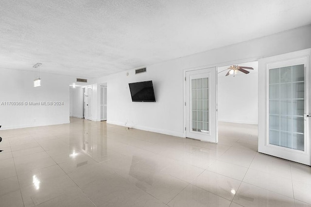 tiled spare room with french doors, a textured ceiling, and ceiling fan