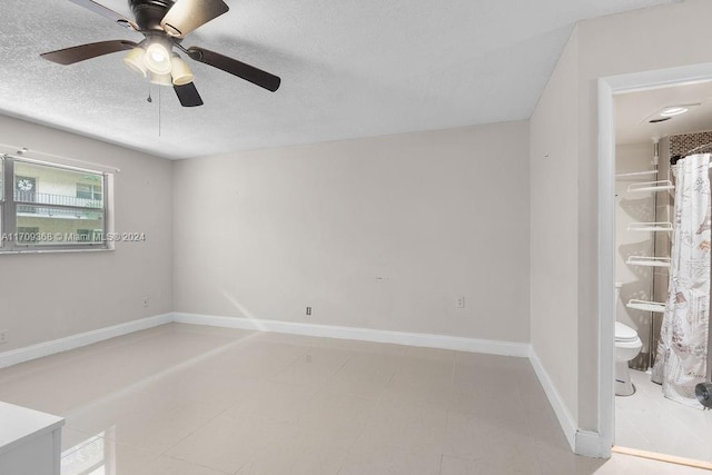 empty room featuring ceiling fan and a textured ceiling