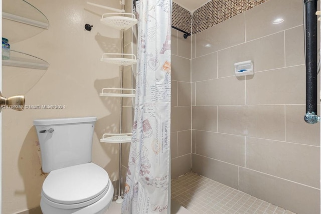 bathroom featuring a shower with shower curtain and toilet