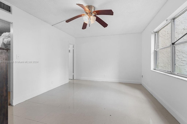 spare room featuring ceiling fan and light tile patterned flooring