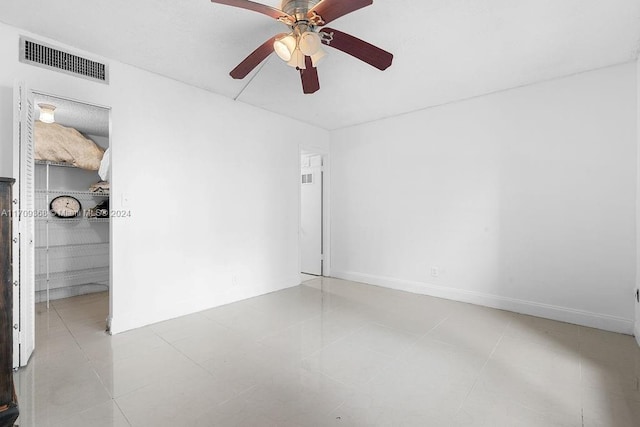 tiled spare room with ceiling fan