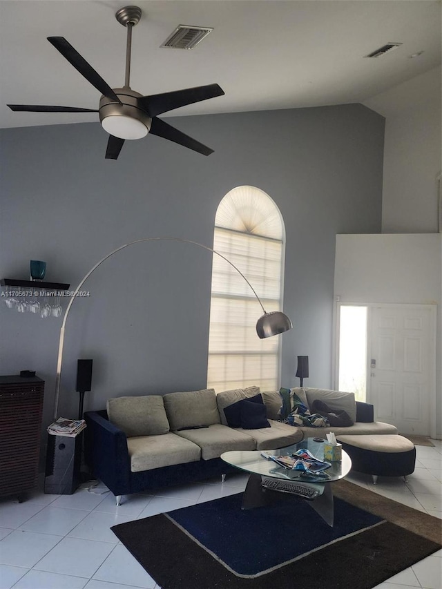 tiled living room with plenty of natural light, ceiling fan, and high vaulted ceiling