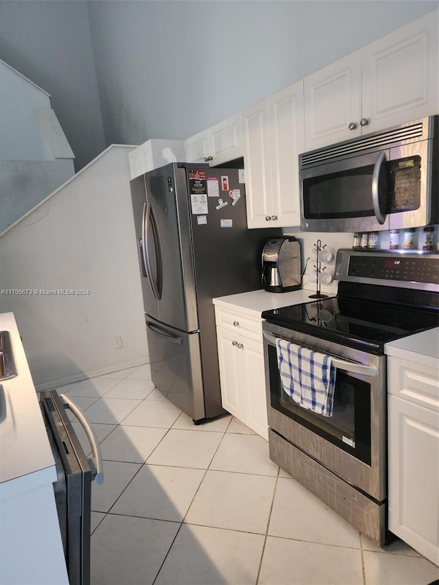 kitchen with white cabinetry, stainless steel appliances, and light tile patterned floors