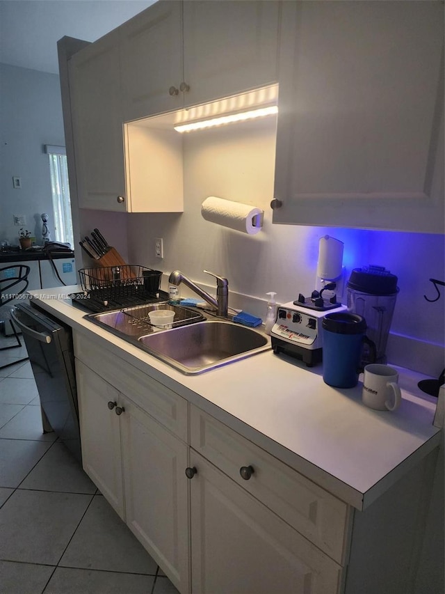 kitchen with white cabinetry, sink, light tile patterned flooring, and black dishwasher