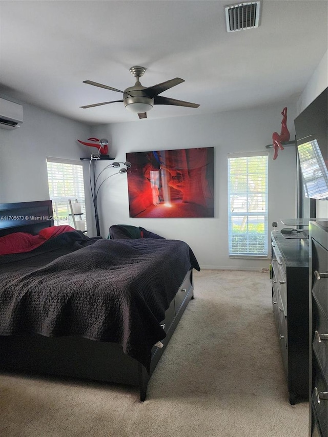 carpeted bedroom featuring a wall mounted AC and ceiling fan