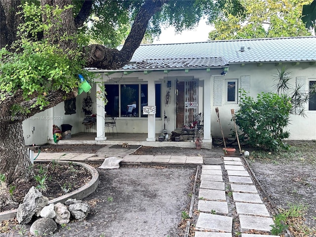 back of property featuring covered porch