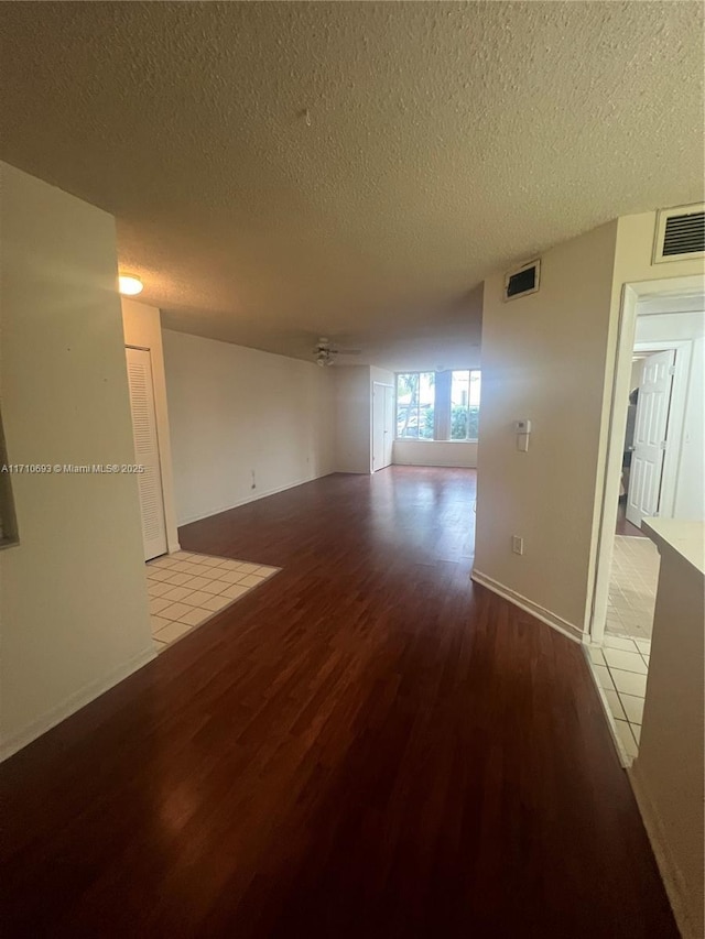 empty room with light wood-type flooring and a textured ceiling