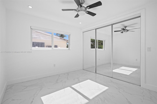 unfurnished bedroom with ceiling fan and a closet