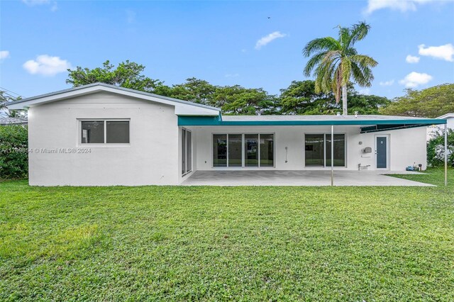 back of property with a yard and a patio area