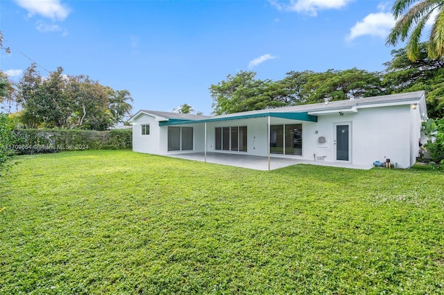 back of house featuring a lawn and a patio area