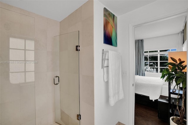 bathroom featuring a shower with shower door and hardwood / wood-style flooring