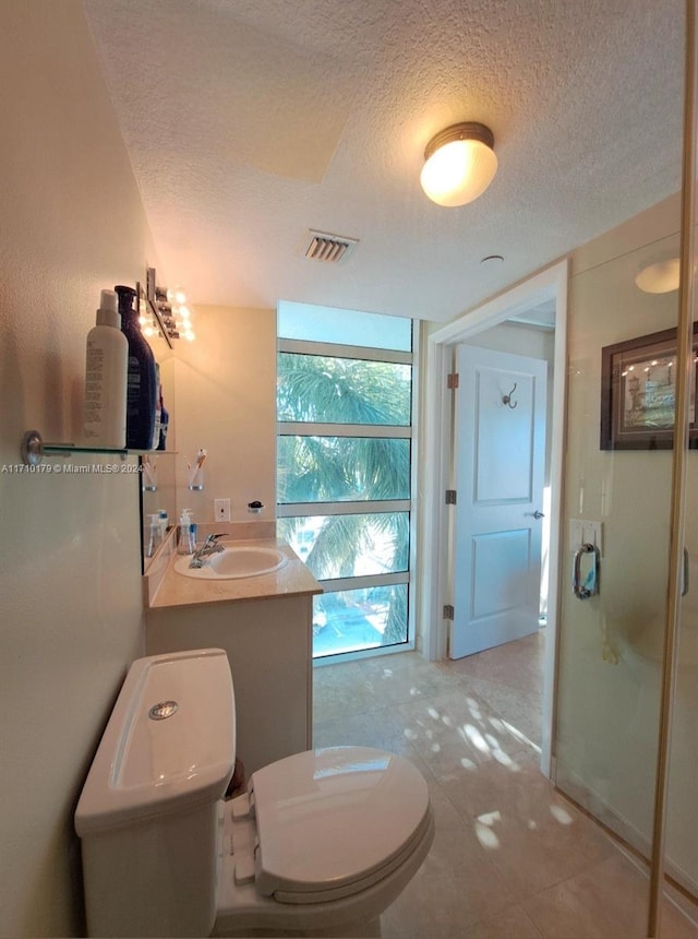 bathroom featuring vanity, toilet, and a textured ceiling