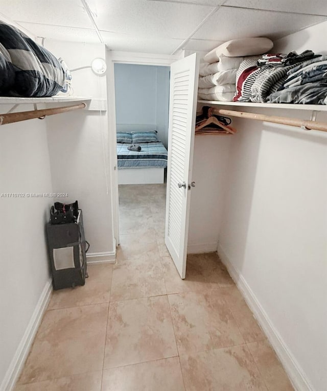 walk in closet featuring a paneled ceiling and light tile patterned floors