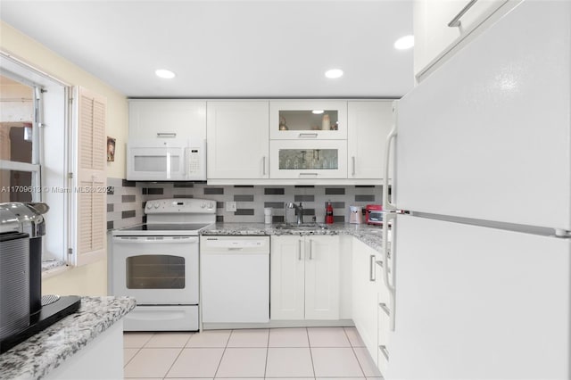 kitchen with decorative backsplash, white cabinetry, white appliances, and sink