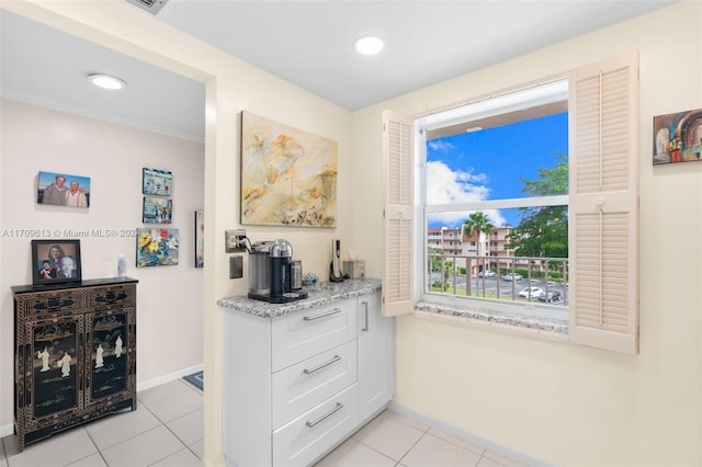 interior space featuring light tile patterned floors and ornamental molding