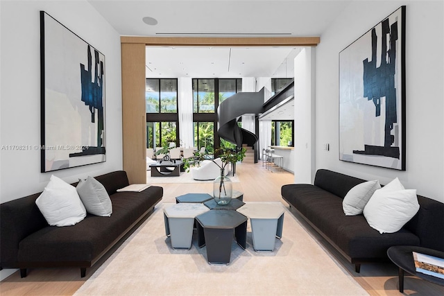 living room with a wealth of natural light, expansive windows, and hardwood / wood-style flooring