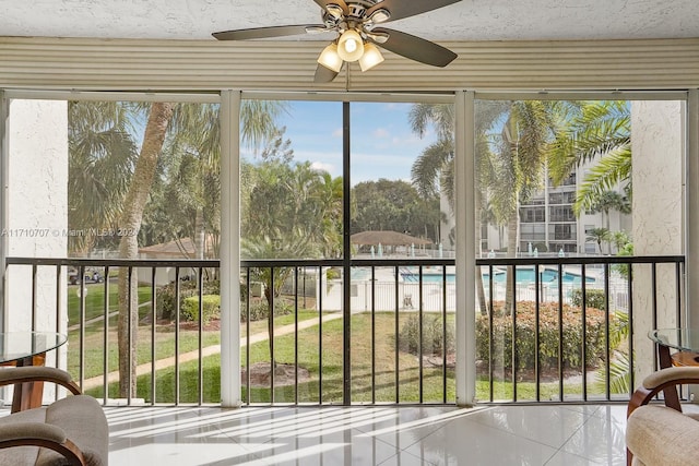 unfurnished sunroom with ceiling fan