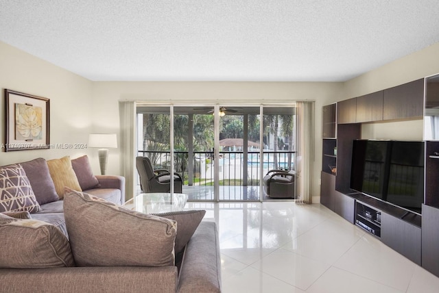 living room featuring ceiling fan, light tile patterned floors, and a textured ceiling