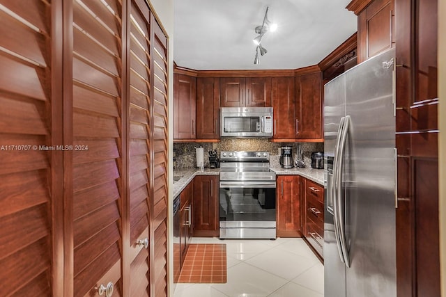 kitchen featuring decorative backsplash, light stone counters, light tile patterned flooring, and appliances with stainless steel finishes