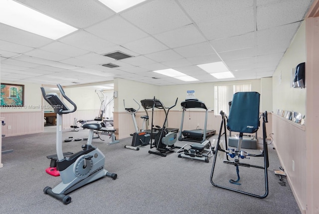 exercise room with carpet floors and a drop ceiling