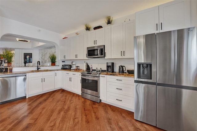 kitchen featuring white cabinetry, sink, light hardwood / wood-style floors, and appliances with stainless steel finishes