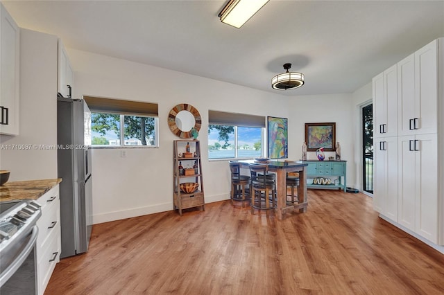 dining room with light wood-type flooring and a wealth of natural light