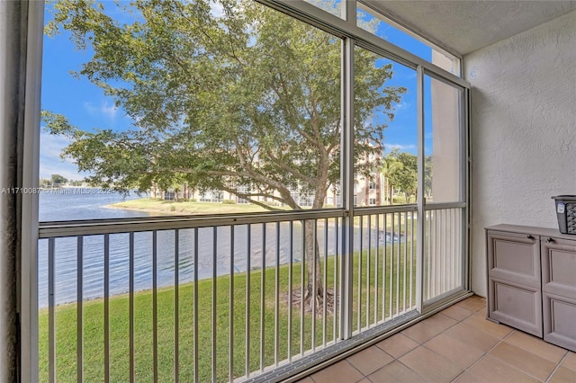 unfurnished sunroom featuring a water view