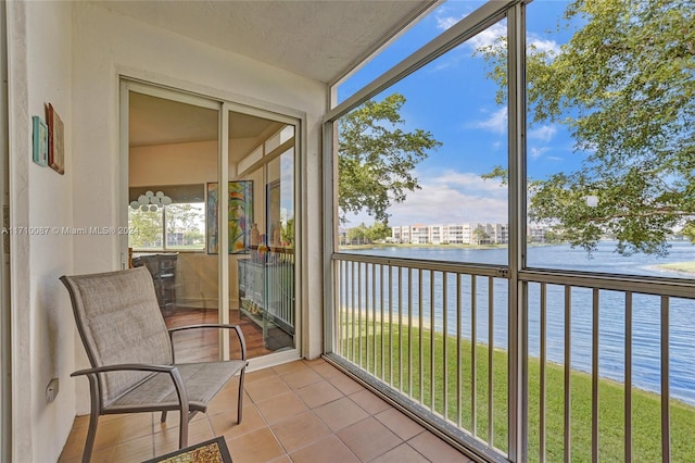 sunroom featuring a water view