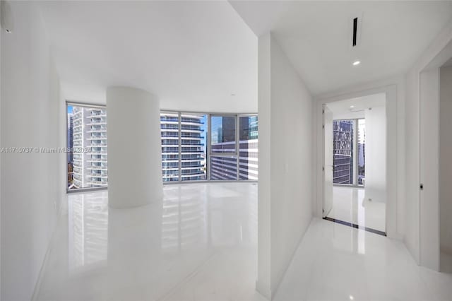 hallway featuring tile patterned floors and a wall of windows