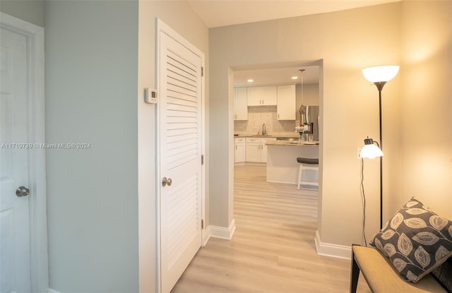 corridor featuring sink and light hardwood / wood-style floors