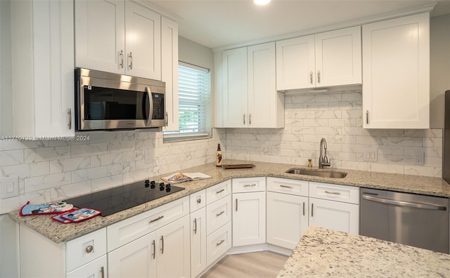 kitchen with light hardwood / wood-style floors, white cabinetry, sink, and appliances with stainless steel finishes