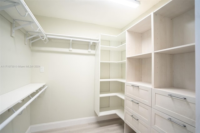 walk in closet with light hardwood / wood-style floors